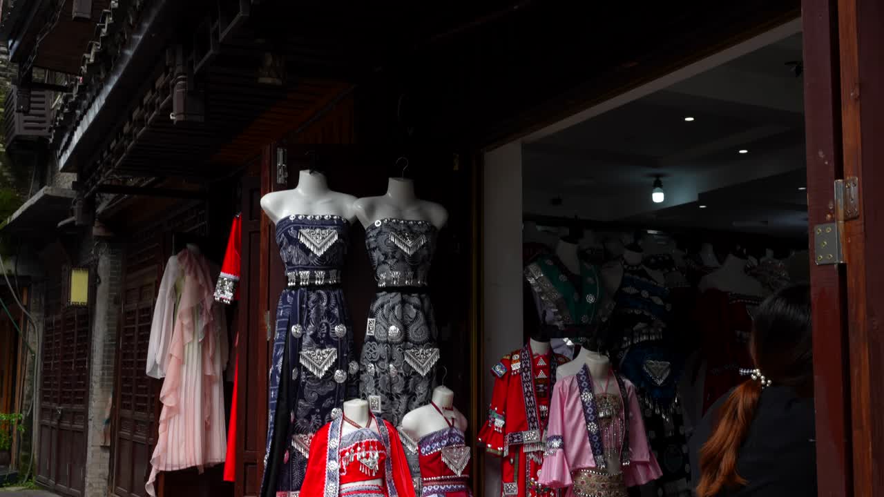 Chinese store with several traditional dresses from different ethnicities on display at Phoenix Ancient Town