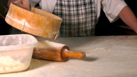 rolling out dough with flour to make turkish pita