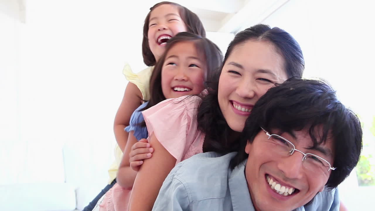 семья игриво лежит друг на друге.