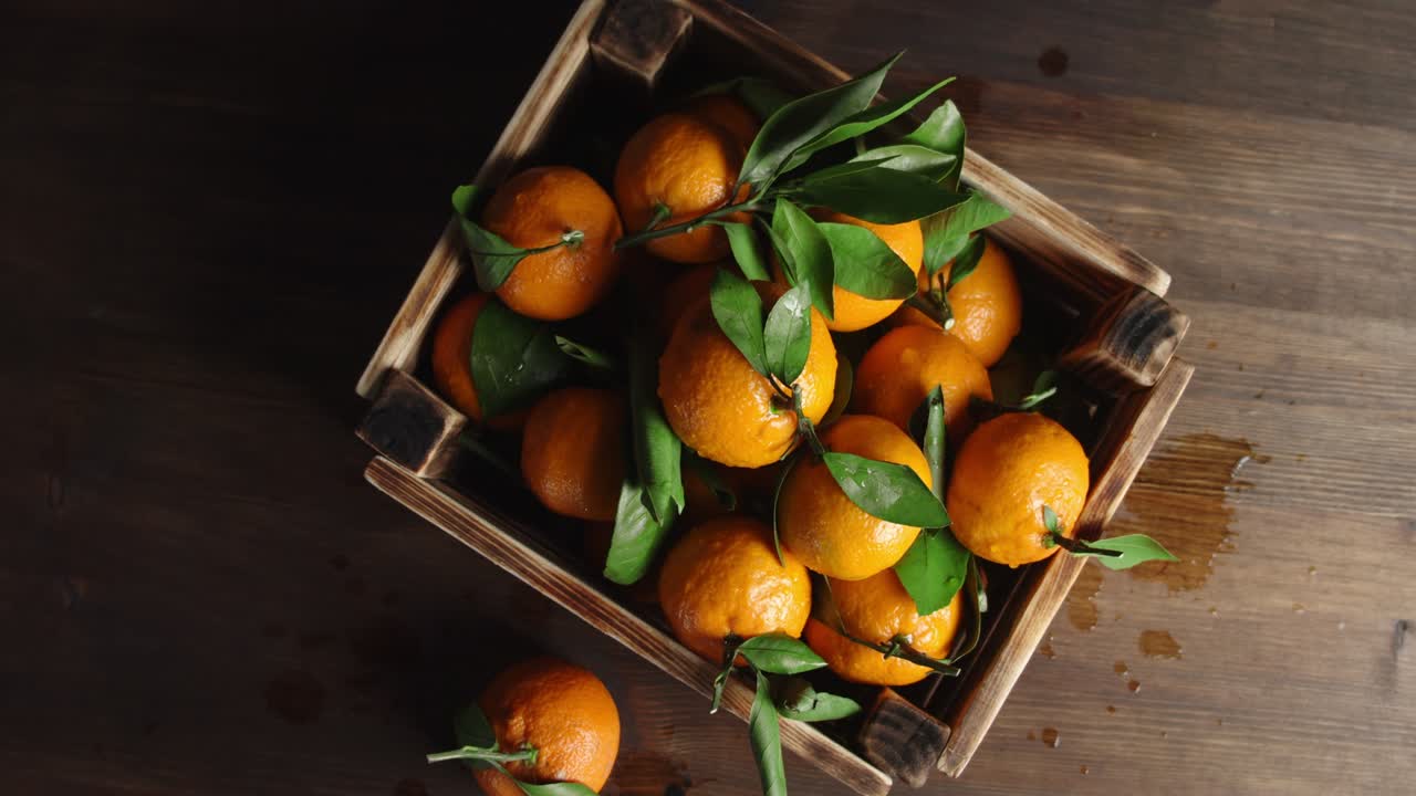 la caja de madera con las mandarinas frescas gira lentamente.