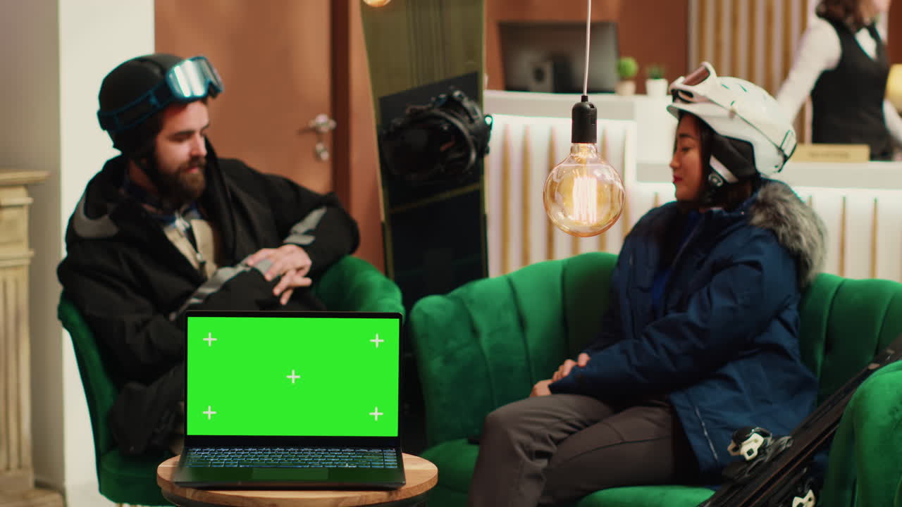 pareja con traje de nieve en el lobby del hotel.