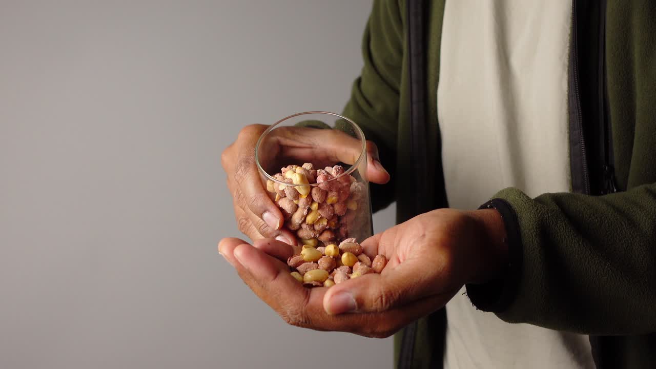 Peanuts in a glass held by a person