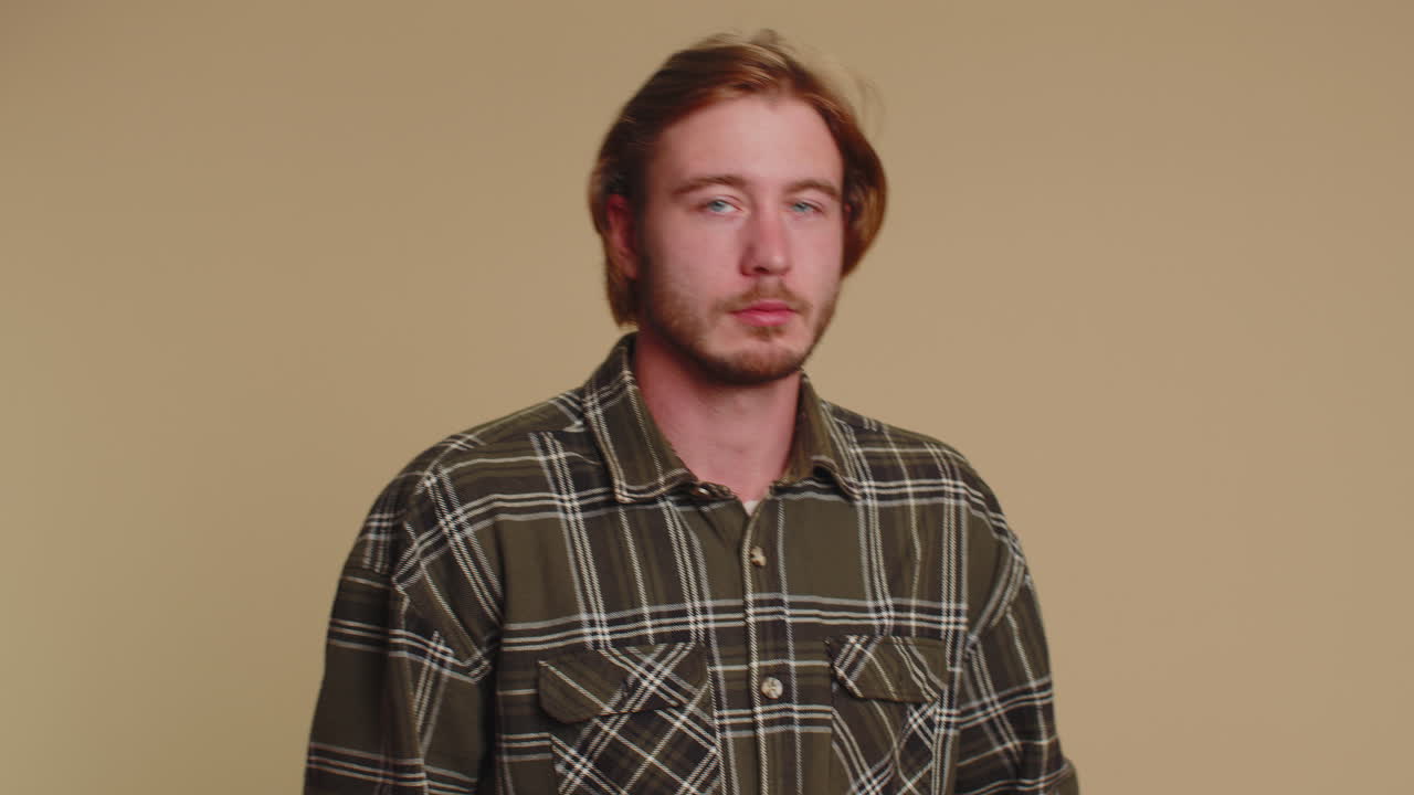 젊은이가 손가락을 입술에  ⁇ 러 침 ⁇ 을 지시합니다. 신호는 비밀을 말하지 않습니다.