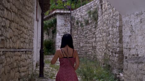 joven turista caminando por el pueblo de piedra mediterráneo