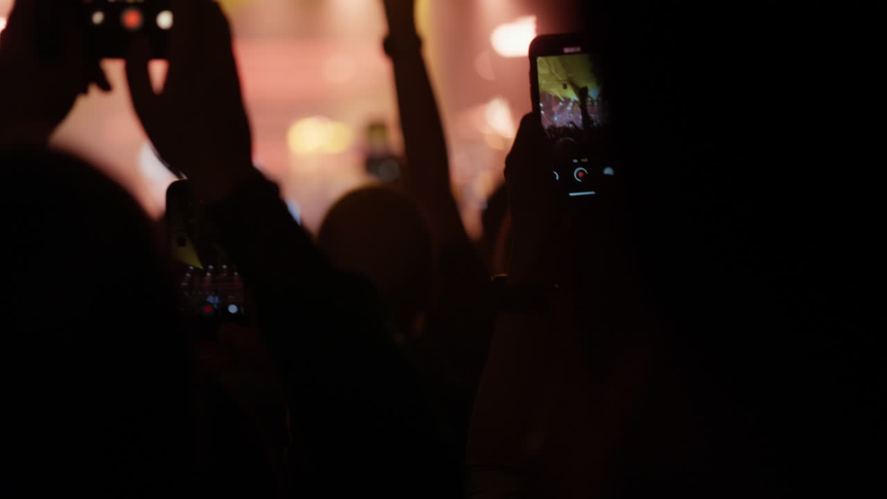 Folla a un concerto che registra un'esibizione dal vivo con smartphone