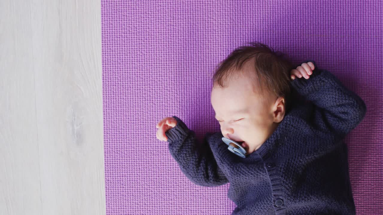 video de un bebé recién nacido caucásico durmiendo en una manta violeta
