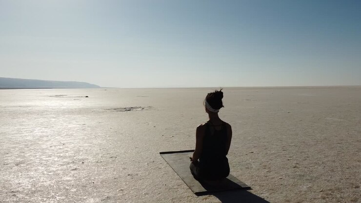 Un'insegnante donna in posa di meditazione sul Lago Tuz, Salar in Turchia.