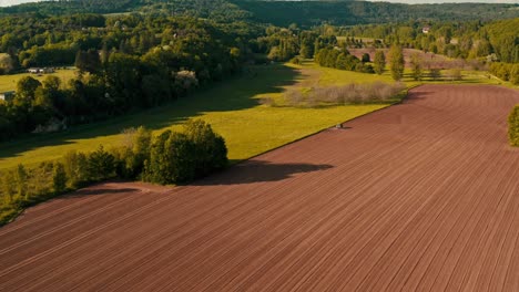 siembra de suelo labrado y agitado preparación para la temporada de crecimiento en un valle exuberante, aérea