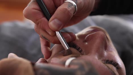 artista de maquillaje masculino trabajando con un modelo femenino