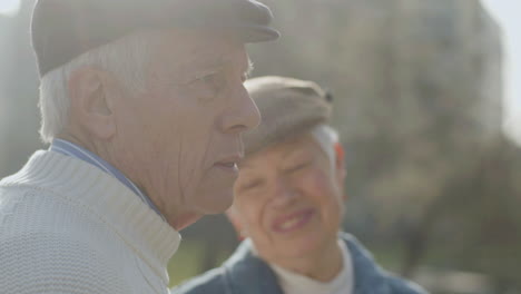 closeup shot of lovely elderly couple hugging outdoors on autumn day