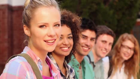 happy students sitting in a row smiling at camera