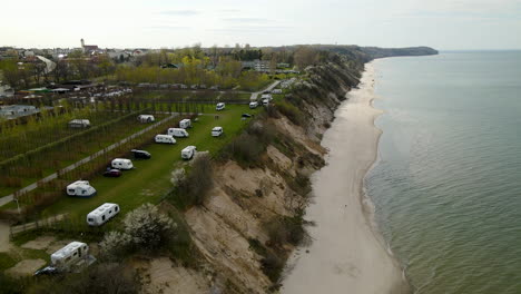 dron powietrzny leci wzdłuż parkingu przyczep kempingowych położonego na klifowym brzegu morza bałtyckiego w ciągu dnia latem w chłapowie w polsce