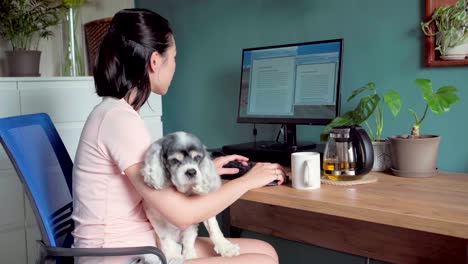 Mujer-Asiática-Trabajando-En-Computadora-Con-Perro-En-Casa