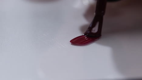 applying maroon nail polish