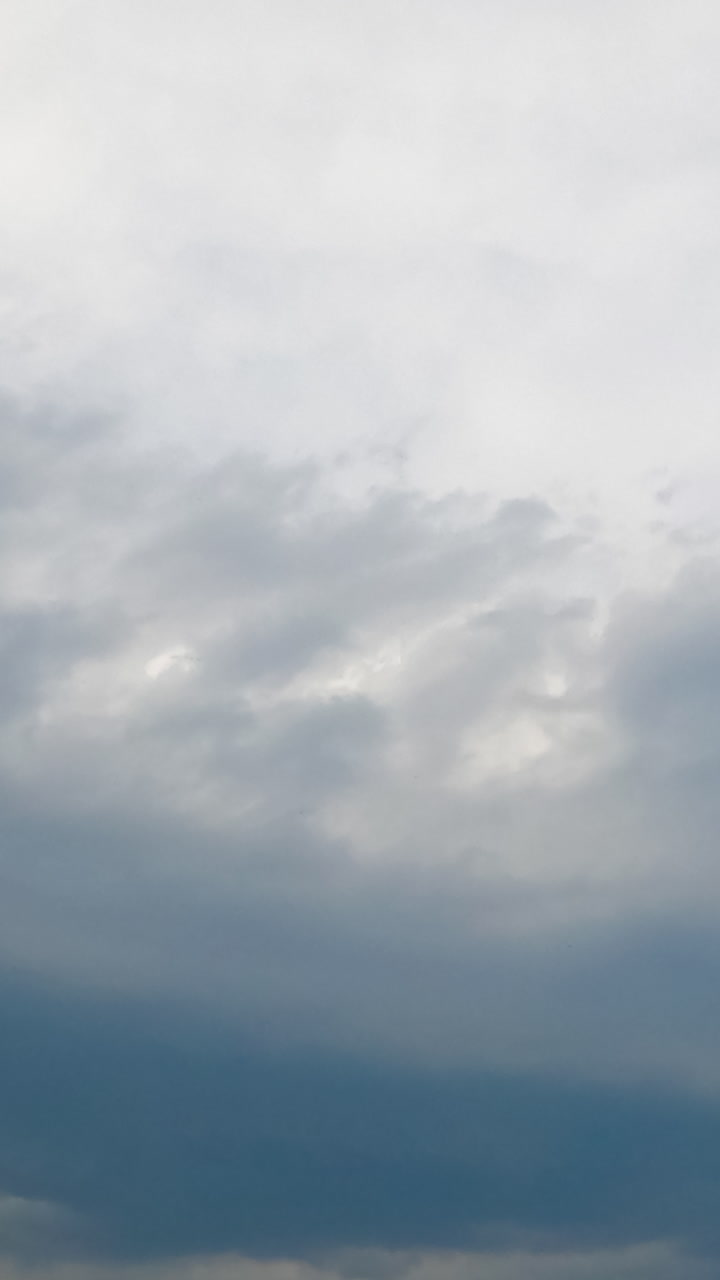 Combination of two diverse types of cloudscape in the atmosphere. Cumulus clouds rise up to the cirrus clouds. Timelapse. Vertical video
