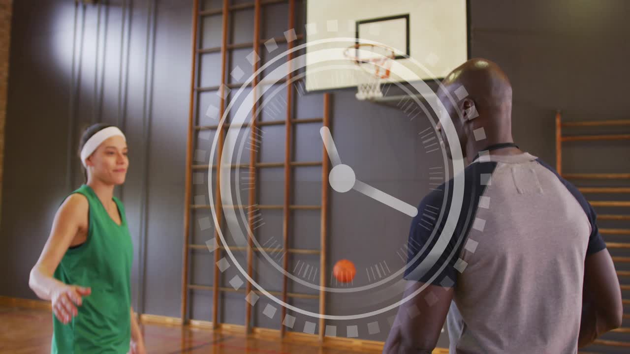Coach timing with device, player releasing ball to hoop in gym, timer overlay tracking training