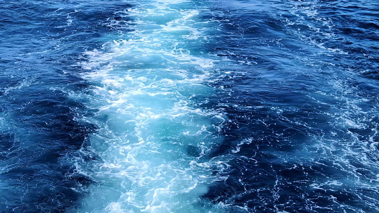 Waters as seen from a motorboat leaving background blue ocean motion foam closeup