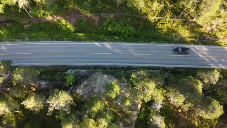 Vista-De-Arriba-Hacia-Abajo-Sobre-Un-Coche-Negro-Que-Pasa-Por-Un-Lago-En-Noruega