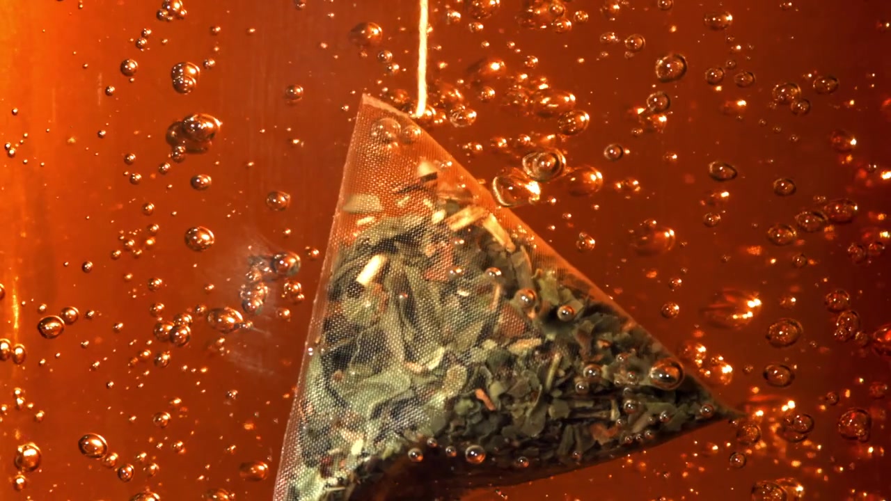 Pyramid Tea Bag Steeping in Hot Water with Bubbles