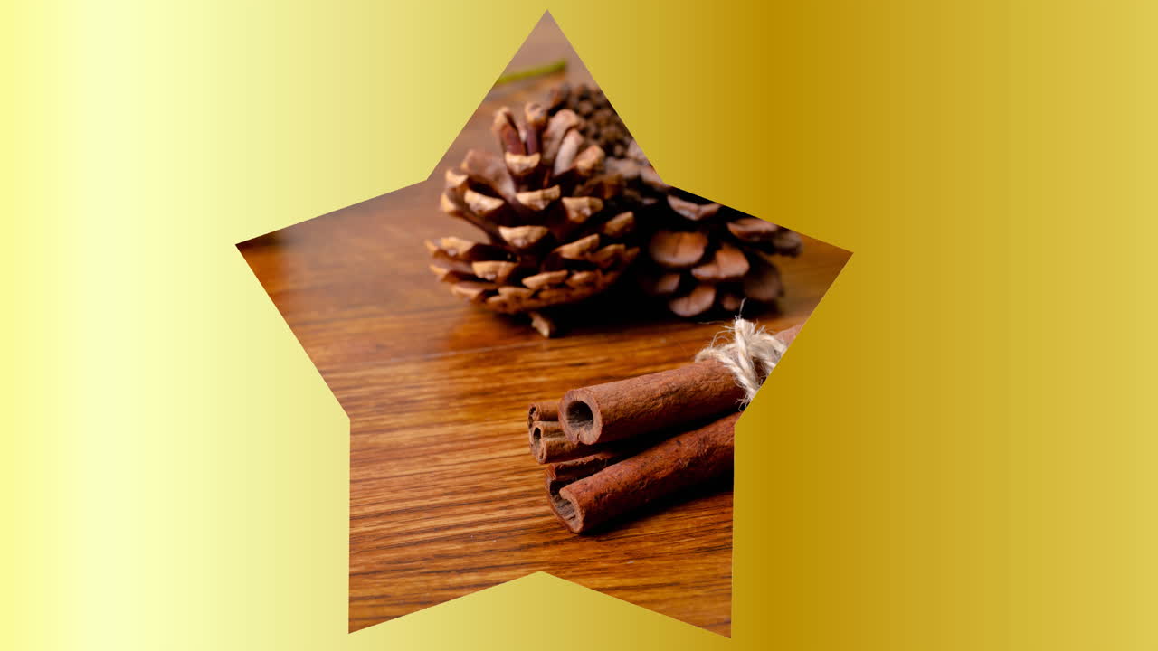 Video of cinnamon and pine cones in star shape on yellow background at christmas