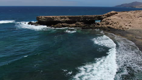 vista aérea en un círculo sobre la playa de la pared en la isla de fuerteventura en un día soleado, lugar popular para el surf y el bodyboard