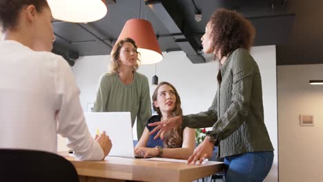 Diversas-Mujeres-De-Negocios-Reuniéndose-Y-Usando-Una-Computadora-Portátil-En-La-Oficina,-En-Cámara-Lenta