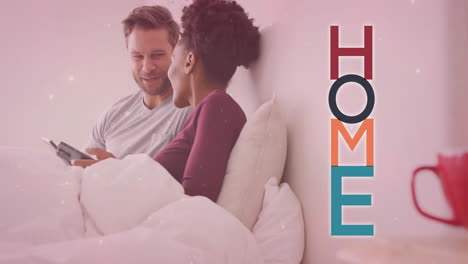 animation of home text over diverse couple using smartphones on bed