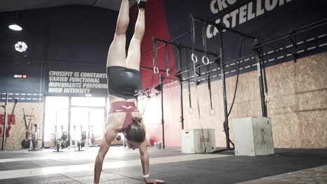 woman performing handstand in a crossfit gym