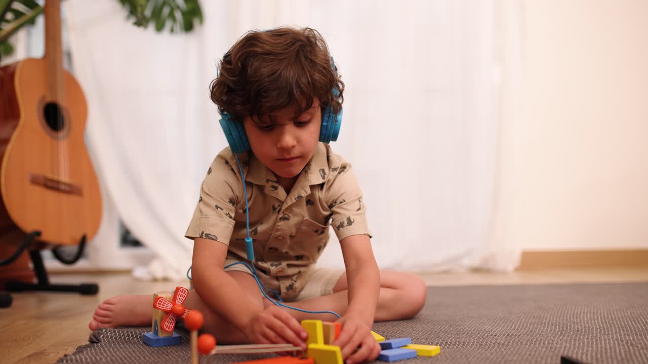 Niño pequeño jugando con juguetes coloridos mientras escucha música