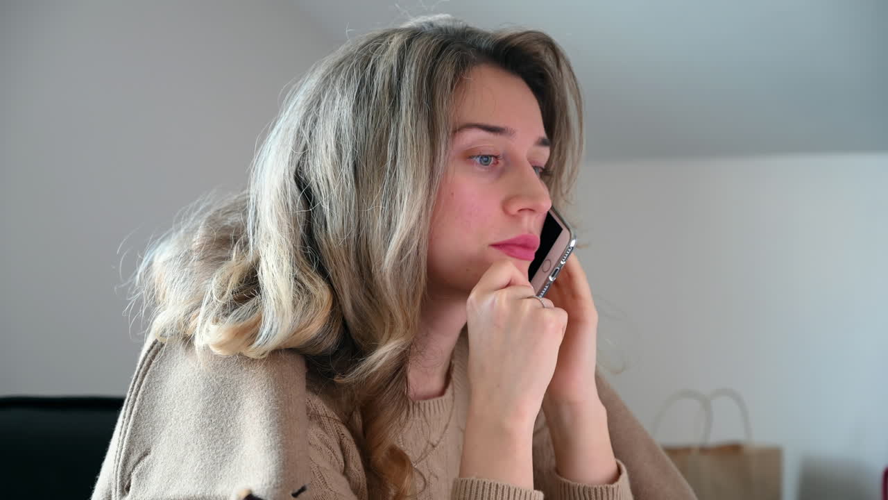 Close up of a woman with blonde hair talking on the phone