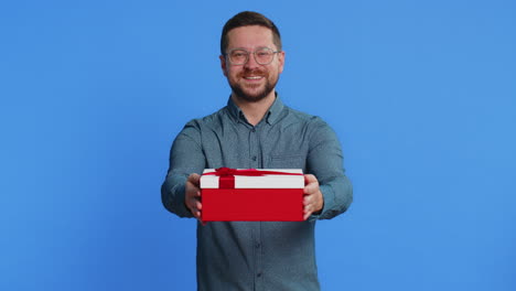 smiling man presenting birthday gift present box stretches out hands promotion discount sale