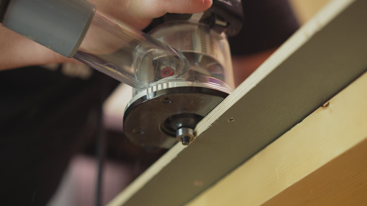 maestro de pulir el borde de los detalles de madera contrachapada con la herramienta en el taller