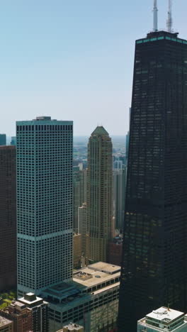 densely built-up urban territory. multi-storied buildings and luxurious skyscrapers at the backdrop of blue clear sky. vertical video
