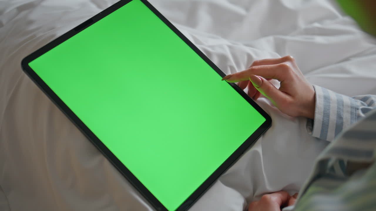 Home girl using chroma key tablet on bed at weekend morning closeup. Woman hands