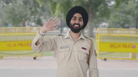 happy sikh indian police man saying hello