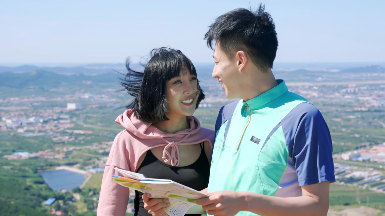 山頂に到達した喜びを語り合いながら地図を見るハイカーのカップル。緑豊かな公園の小道を歩き、新鮮な空気を楽しみ、都会の喧騒の中で心の平穏を見出している。