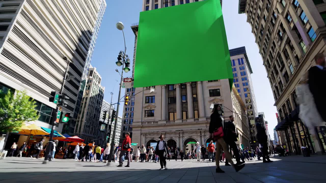 Video di paesaggio urbano dal basso con uno schermo verde su una facciata di un edificio, che cattura pedoni indaffarati