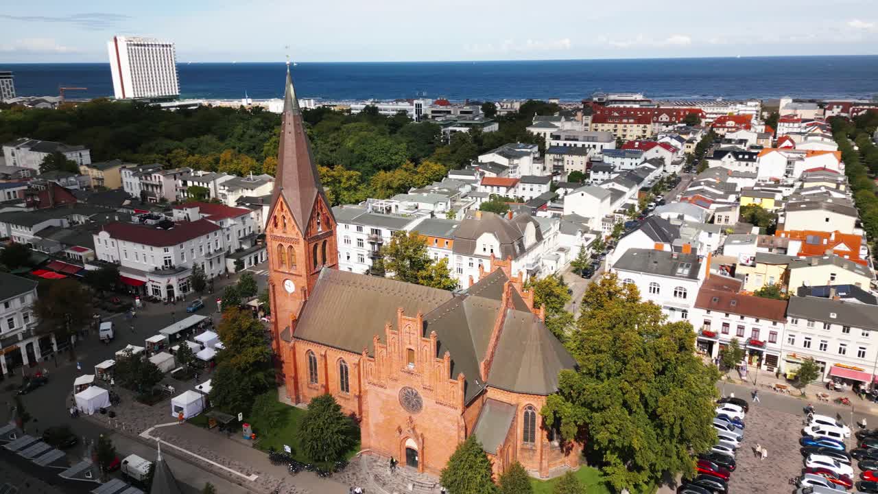 iglesia en una pequeña ciudad junto al mar, mar azul en el fondo, mar báltico, warnemünde, dron