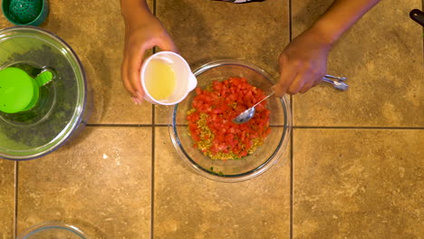 measuring freshly squeezed lemon juice for a tomato and quinoa homemade vegan recipe