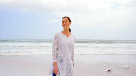 Front-view-of-young-caucasian-woman-standing-at-beach-on-a-sunny-day-4k-