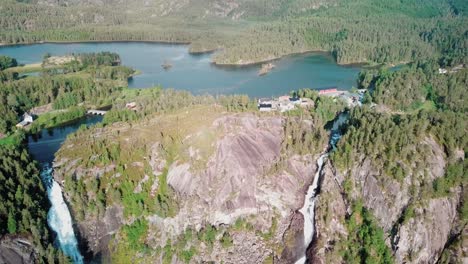 Crane-up-drone-shot-over-two-large-waterfalls-in-Norway-with-lake-Lotevatnet-in-the-background