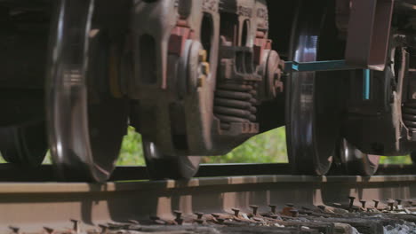 extreme closeup of freight train wheels on a train track passing by camera