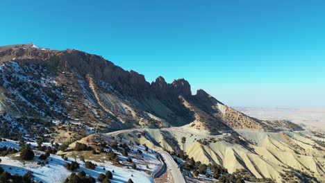 Snow-covered-mountains-in-Afghanistan,-set-against-a-serene,-wintry-environment,-Aerial-landscape-of-snow-capped-mountains-in-Afghanistan