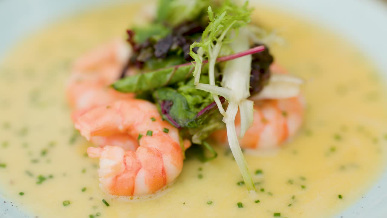 Shrimp arranged on creamy grits, topped with greens, captured in soft natural light, shallow focus
