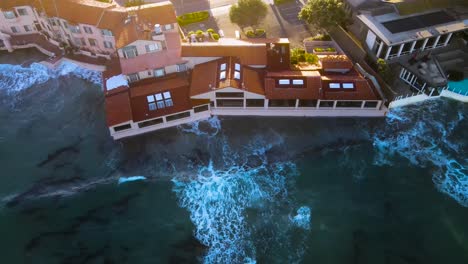 ocean waves crash against oceanfront homes in san diego