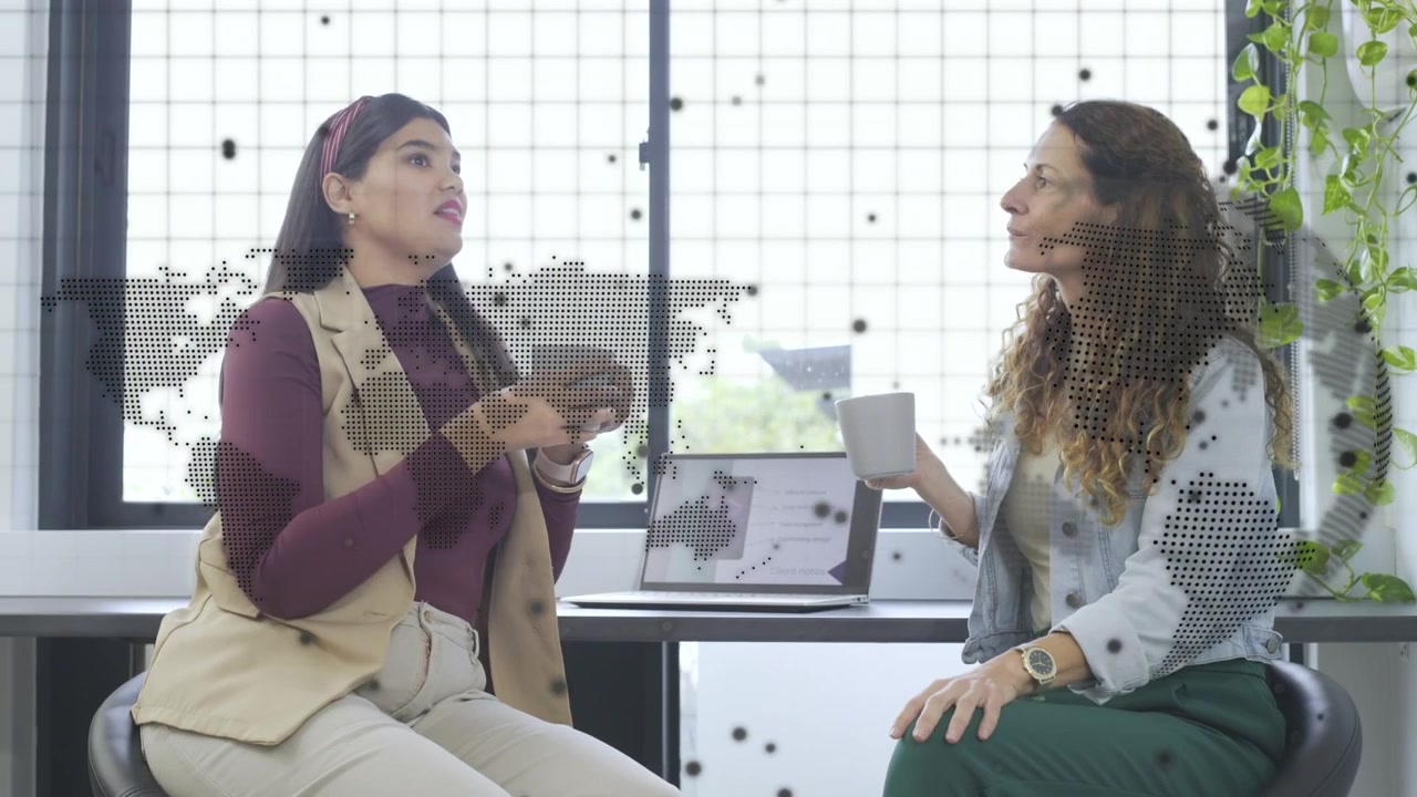 Donna a sinistra che gesticola per iniziare, colleghi che discutono di affari mentre una mappa a punti reagisce ai movimenti su un tablet.