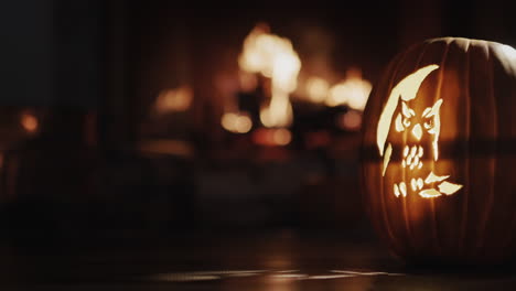 A-pumpkin-with-a-luminous-muzzle-stands-in-a-dark-room-by-the-fireplace