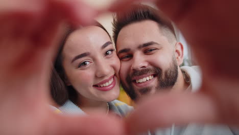 family married couple makes symbol of love, showing heart sign to camera, express romantic feelings