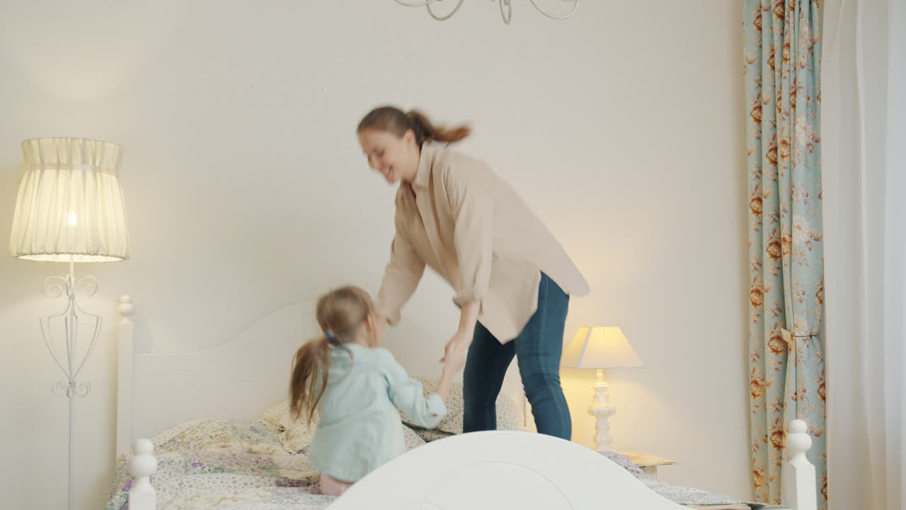 Mother and Daughter Jumping on Bed