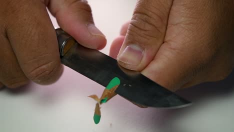 Footage-of-hands-slowly-sharpening-a-pencil-and-some-coloured-pencils-with-a-sharp-knife